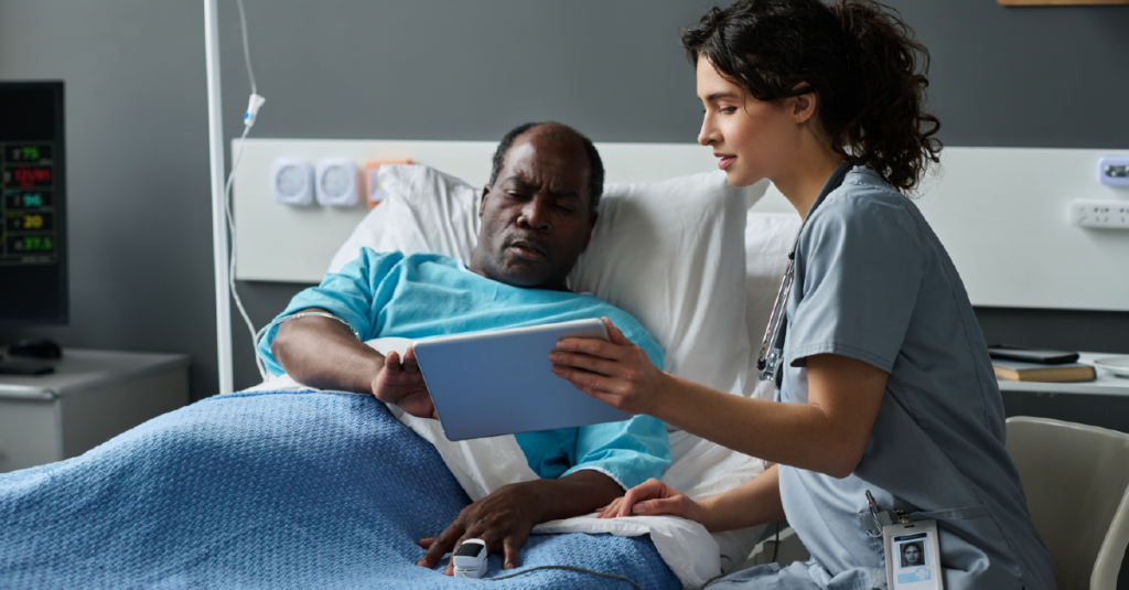 Man in hospital bed with nurse at bedside